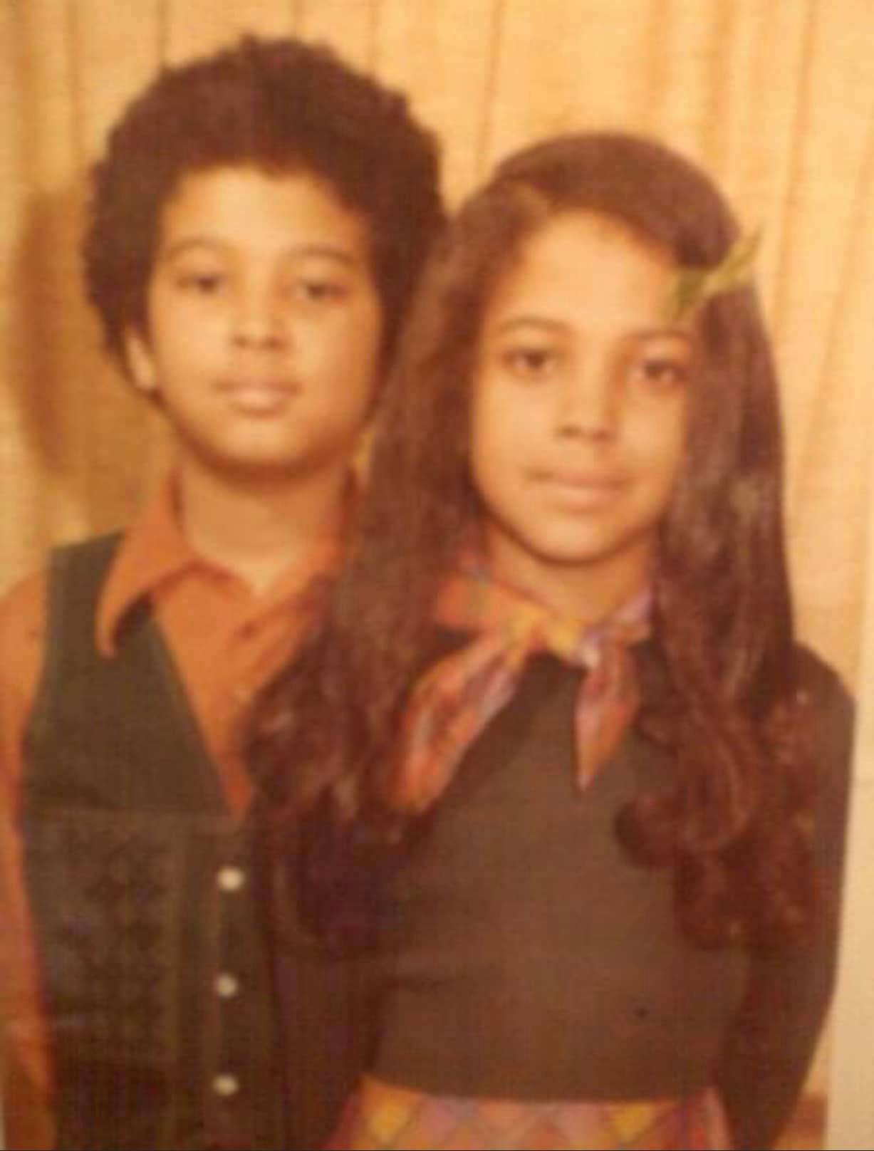 Kimberly Craig's childhood photo in a black tops with checked scarf on her neck with her brother Brian.
